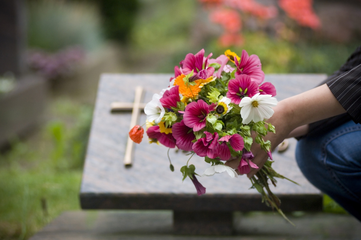 Bouquet de fleurs devant une tombe